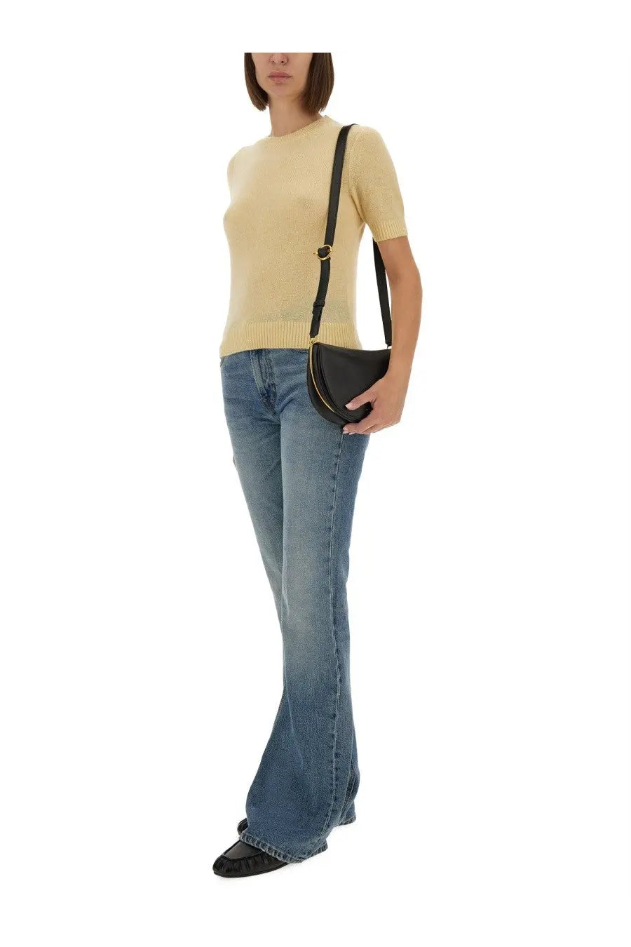 Black leather crescent-shaped crossbody bag with gold-tone hardware paired with beige guest in residence shirt