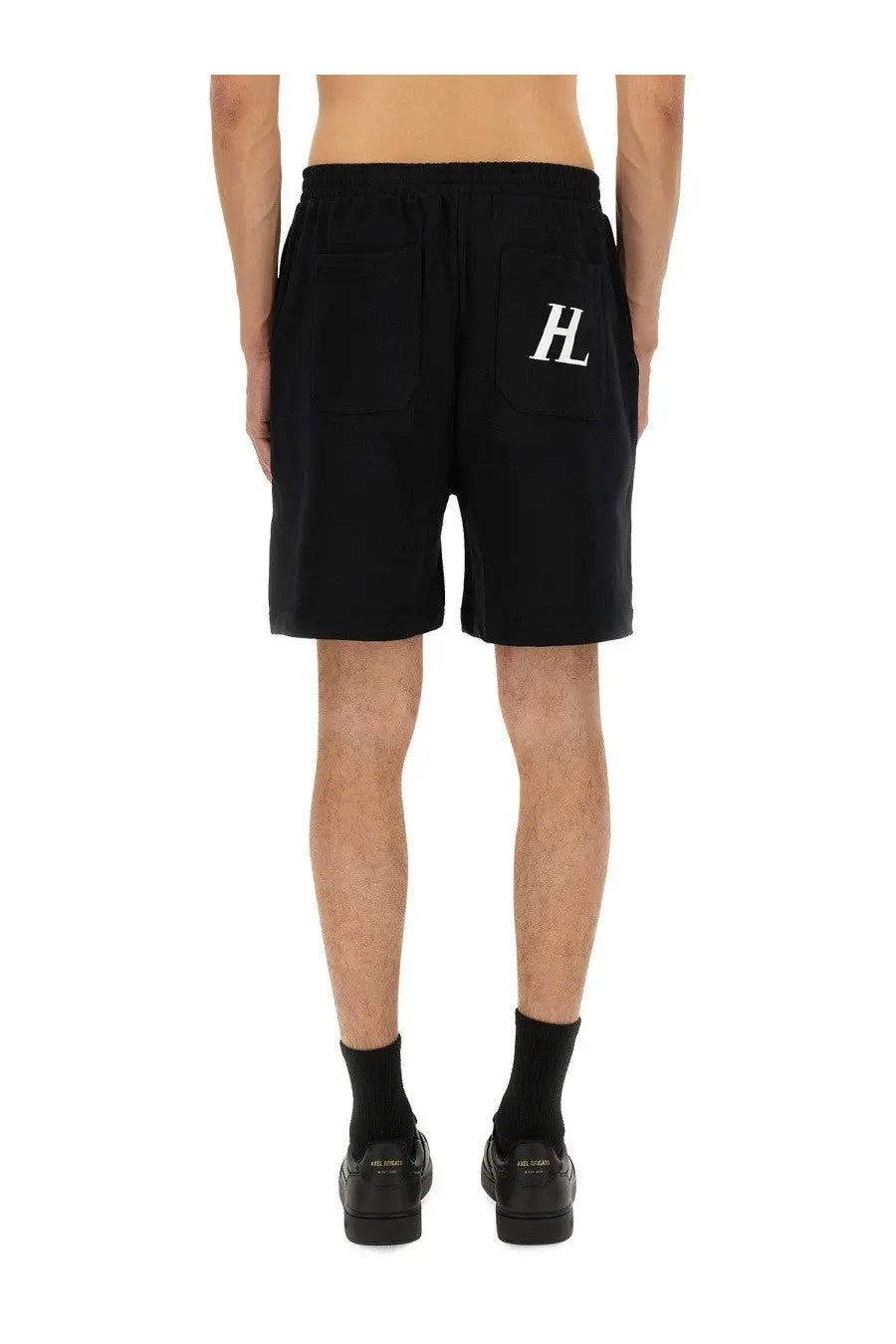 Back side of black helmut lang men’s athletic shorts with white hl logo on the back pocket