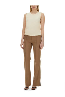 A pair of tan straight-leg trousers with a subtle side slit at the ankle complementing helmut lang pink jersey tank top