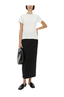 Black leather tote bag with sleek minimalist design paired with helmut lang women’s white shirt
