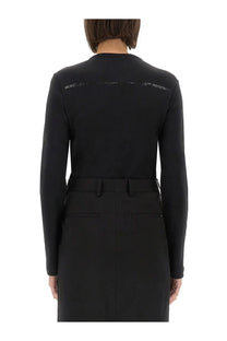 Back view of Helmut Lang women’s slim fit black long-sleeved top with subtle white text across the upper back