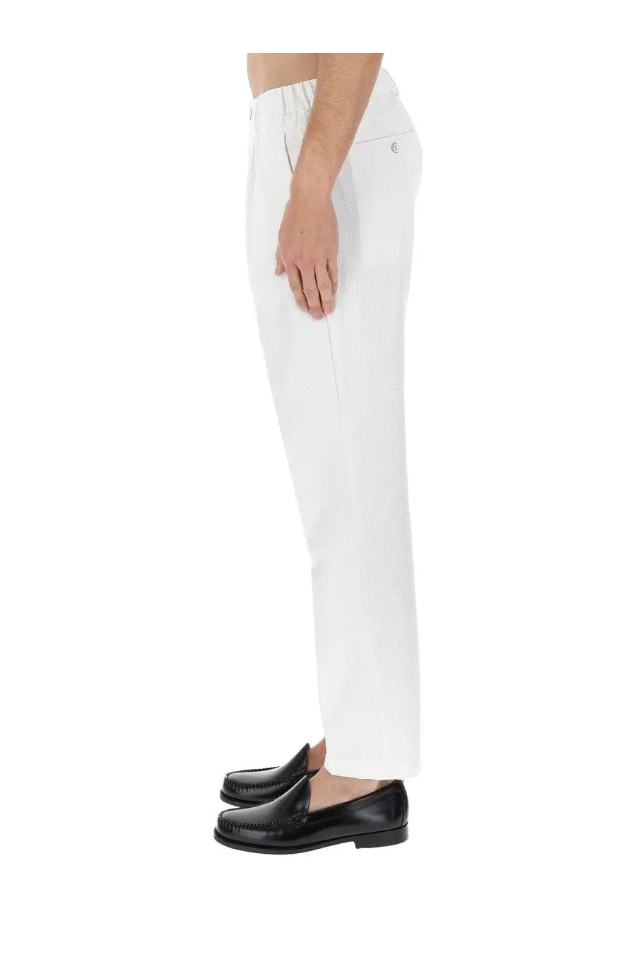 White tailored trousers with subtle elastic waistband and small logo on back pocket paired with black leather loafers
