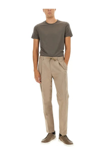 Beige chino trousers with drawstring waist and subtle pleats paired with herno men’s grey wool shirt visible from front