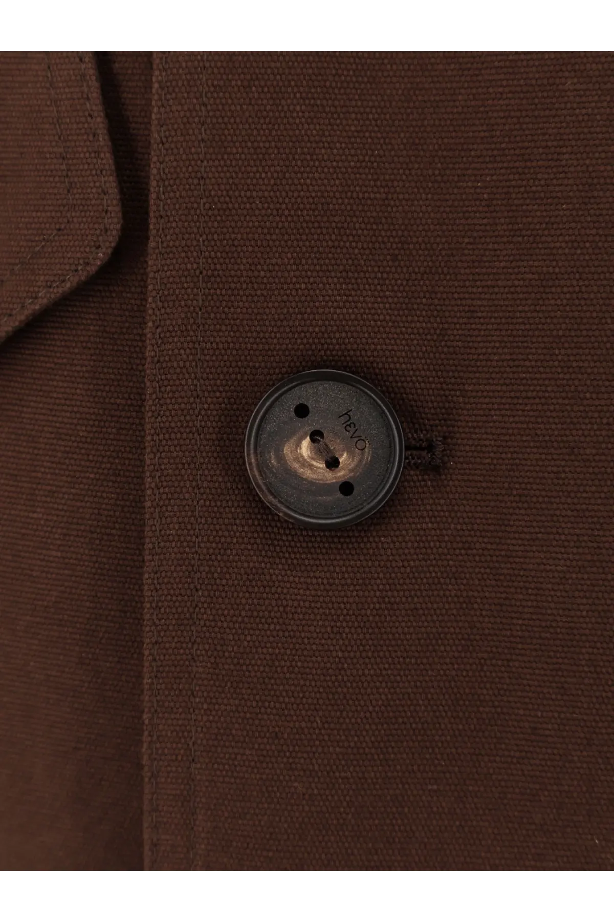 A dark metallic button with worn finish and engraved text on hevò men’s isola di san pietro brown cotton jacket