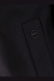 Black hevò men’s loco virgin wool coat button with four silver dots on dark wool fabric close-up view