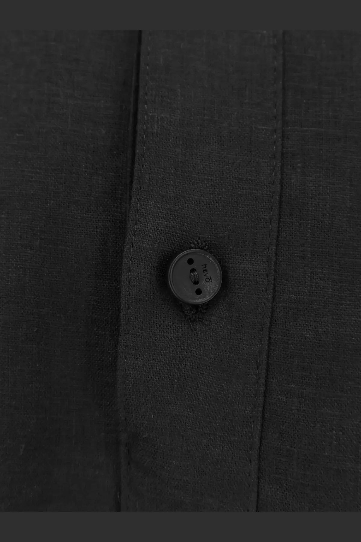 Dark gray hugo button on the textured fabric placket of hevò men’s montursi black linen and viscose shirt