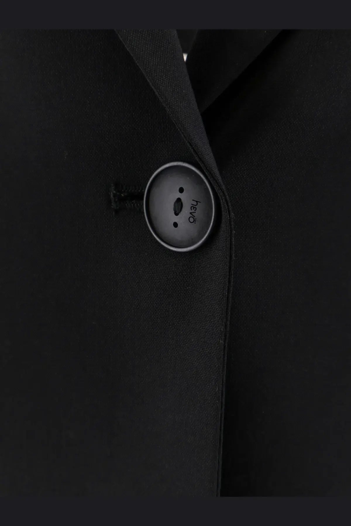 A sleek matte black button with a silver rim from hevò womens frigole virgin sheeps wool black suit