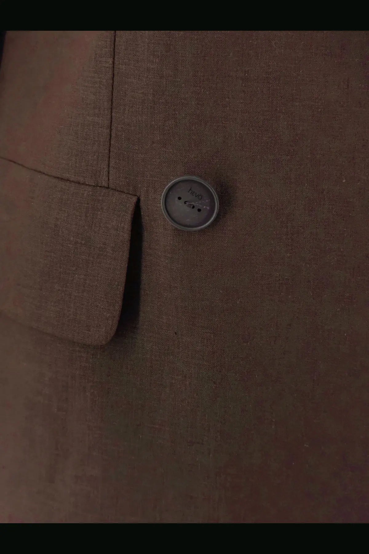 A round gray textured button with three holes on the hevò women’s rocchetta linen and viscose brown suit