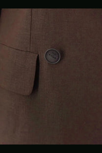 A round gray textured button with three holes on the hevò women’s rocchetta linen and viscose brown suit