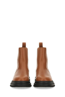 Hogan women’s chelsea boot brown tan leather with black rubber soles showing the back side of the product