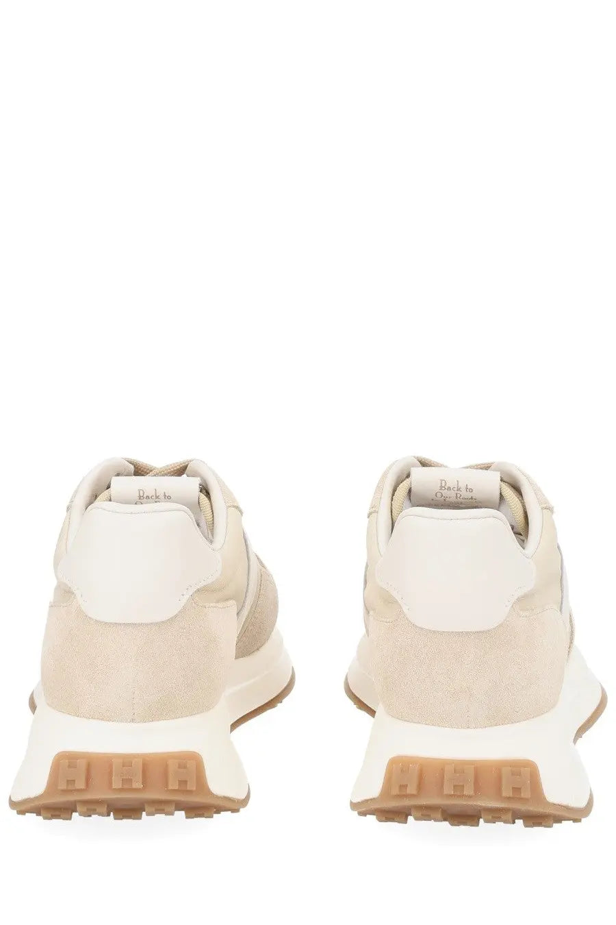 Hogan women’s sneaker beige in beige and white suede with chunky tan rubber sole viewed from the back side