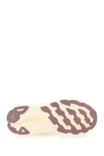The sole of a beige and brown hoka one one clifton ONE9 running shoe with textured patterned tread design