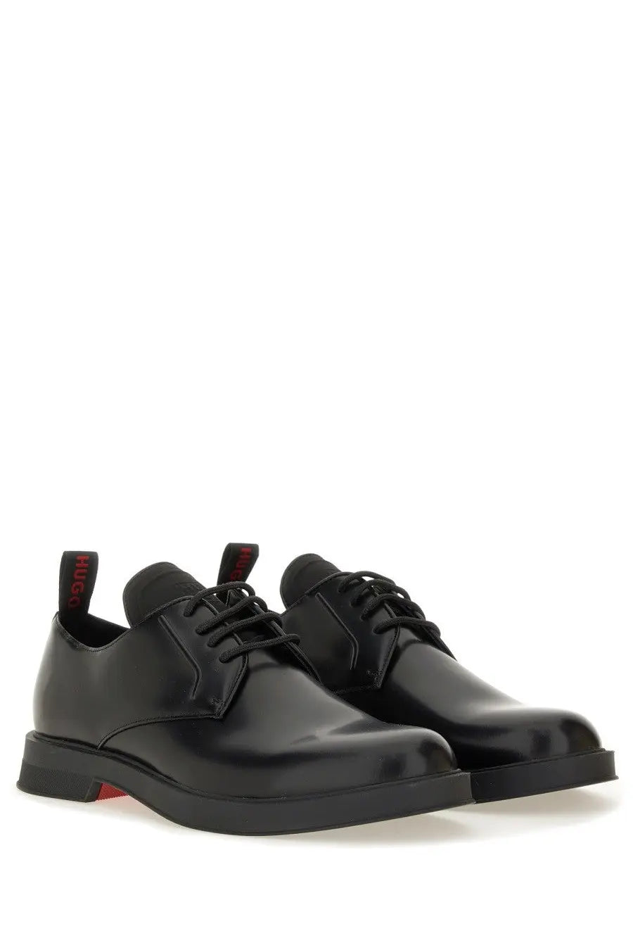 Black patent leather derby shoes with red branding on heel tabs and subtle red sole accent by hugo boss