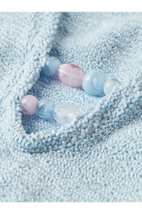 A delicate bracelet of smooth translucent beads in pastel blue and pink complements hunza g womens adriana swimsuit