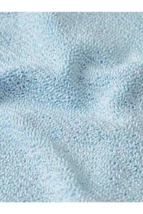 Soft light blue terry cloth towel with plush texture shown alongside Hunza G women’s crinkle fabric one piece swimsuit blue