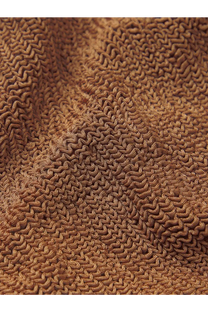 A close-up of a brown textured towel with a wavy looped knit pattern for hunza g women’s crinkle fabric one piece swimsuit