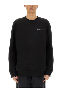 Black ih nom uh nit crewneck sweatshirt with subtle white embroidered crown mask print on left chest