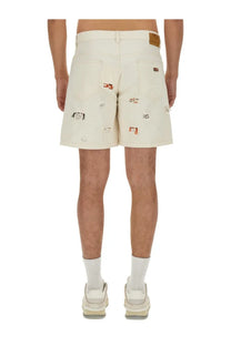 Cream-colored denim bermuda shorts with distressed patchwork and orange and black embroidered logos by isabel marant