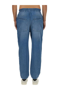 Back view of isabel marant men’s blue cotton denim jogger pants with elastic waistband and two back pockets