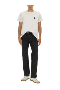 White crew-neck t-shirt with small black embroidered logo on left chest paired with isabel marant men’s jeans lewys black
