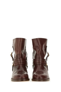 Isabel Marant women’s dark brown patent leather ankle boots with gold-tone buckle straps front view