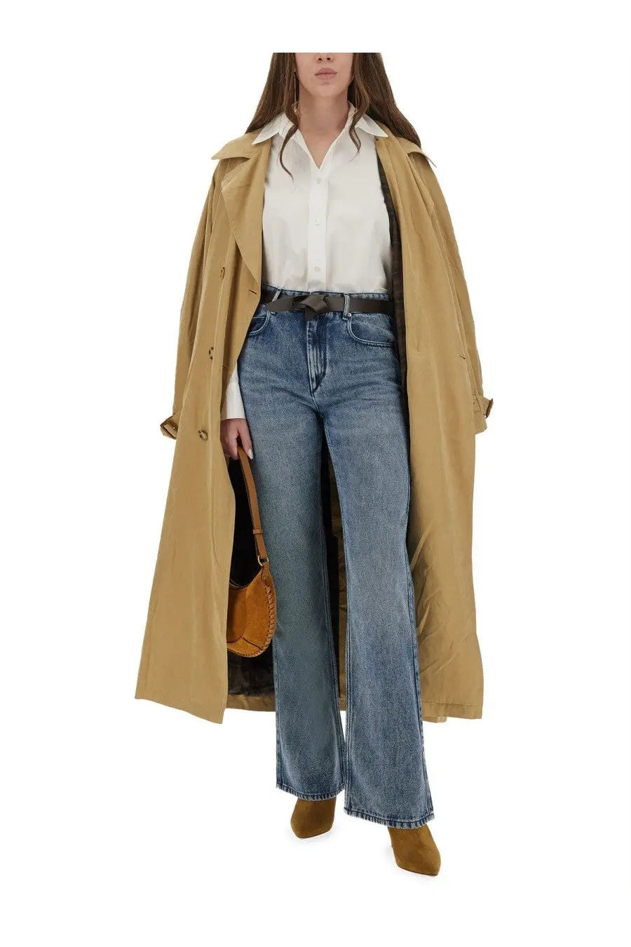 Tan trench coat with classic collar and buttoned front worn over isabel marant women’s fabriza white shirt and blue jeans