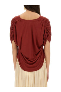 Isabel Marant women’s rust-colored soft blouse with ruched sleeves and draped back design shown from the back