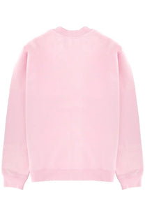A soft pink jacquemus men’s crewneck sweatshirt with smooth plain fabric and ribbed cuffs