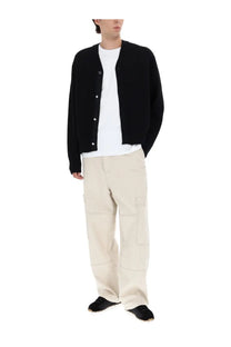 Black knit cardigan with button closure paired with jacquemus men’s beige le cargo de nimes carré pants
