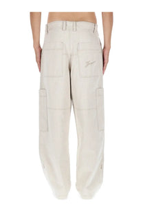Beige jacquemus men’s le cargo de nimes carré pants shown from the back with multiple pockets and embroidered logo