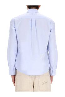 Light blue jacquemus men’s le simon long-sleeved shirt with subtle pleated back and embroidered logo on lower left side