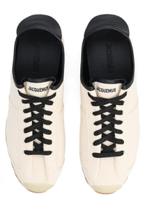Cream-colored canvas jacquemus men’s les tennis sneaker with black laces and rubber toe caps in beige