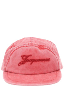 A faded coral pink five-panel cap with a flat brim and dark red jasper embroidery by jacquemus