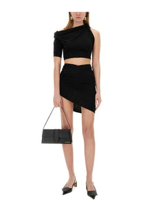 Black leather clutch with minimalist design and gold-tone hardware paired with Jacquemus The Drapeado mini skirt black