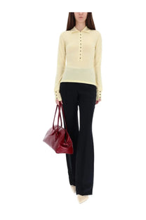 A glossy red leather handbag with bow detail styled with jacquemus womens knitted polo yellow
