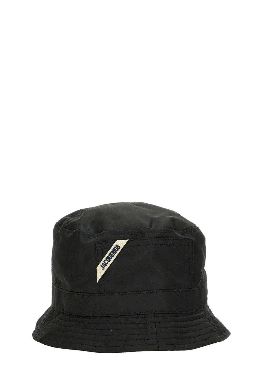 Black jacquemus women’s le bob ovalie bucket hat featuring a diagonal cream label with black jacquemus lettering