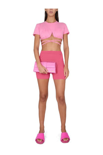 Pink quilted leather clutch purse paired with jacquemus women’s shorts pralu blue outfit