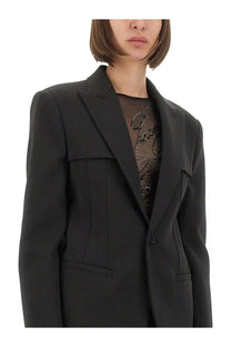Black tailored blazer by Jean Paul Gaultier with structured shoulders and flap pockets for women’s formal wear