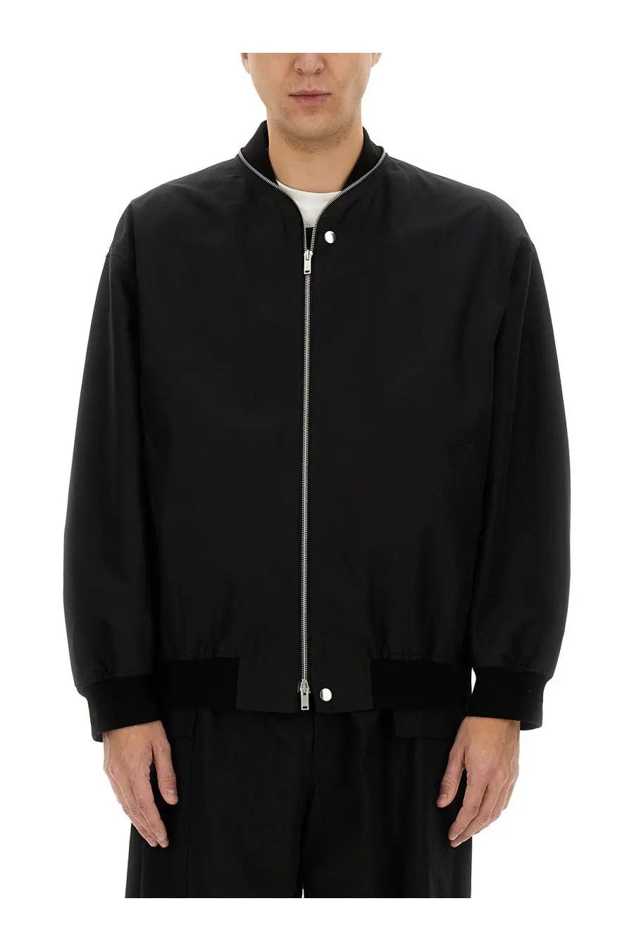 Jil Sander men’s black bomber jacket featuring a silver zipper and matching button accents in sleek design