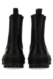 Jil Sander men’s Chelsea boot in black leather with a chunky ribbed rubber sole shown from the back side
