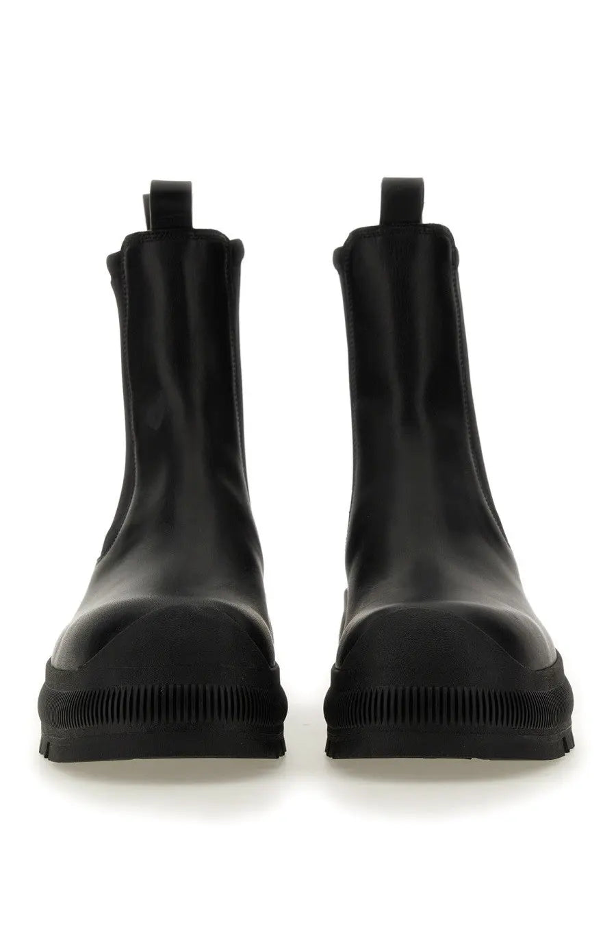 Black patent leather jil sander men’s chelsea boots with chunky rubber sole and pull tabs shown from the back side