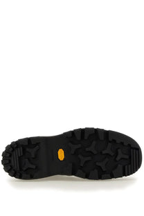 Black rubber outsole with aggressive tread pattern and yellow vibram logo on jil sander men’s chelsea boot black