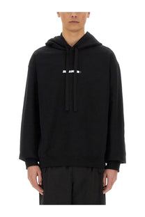 Black oversized hoodie with white jil sander logo across the chest for men in cotton material
