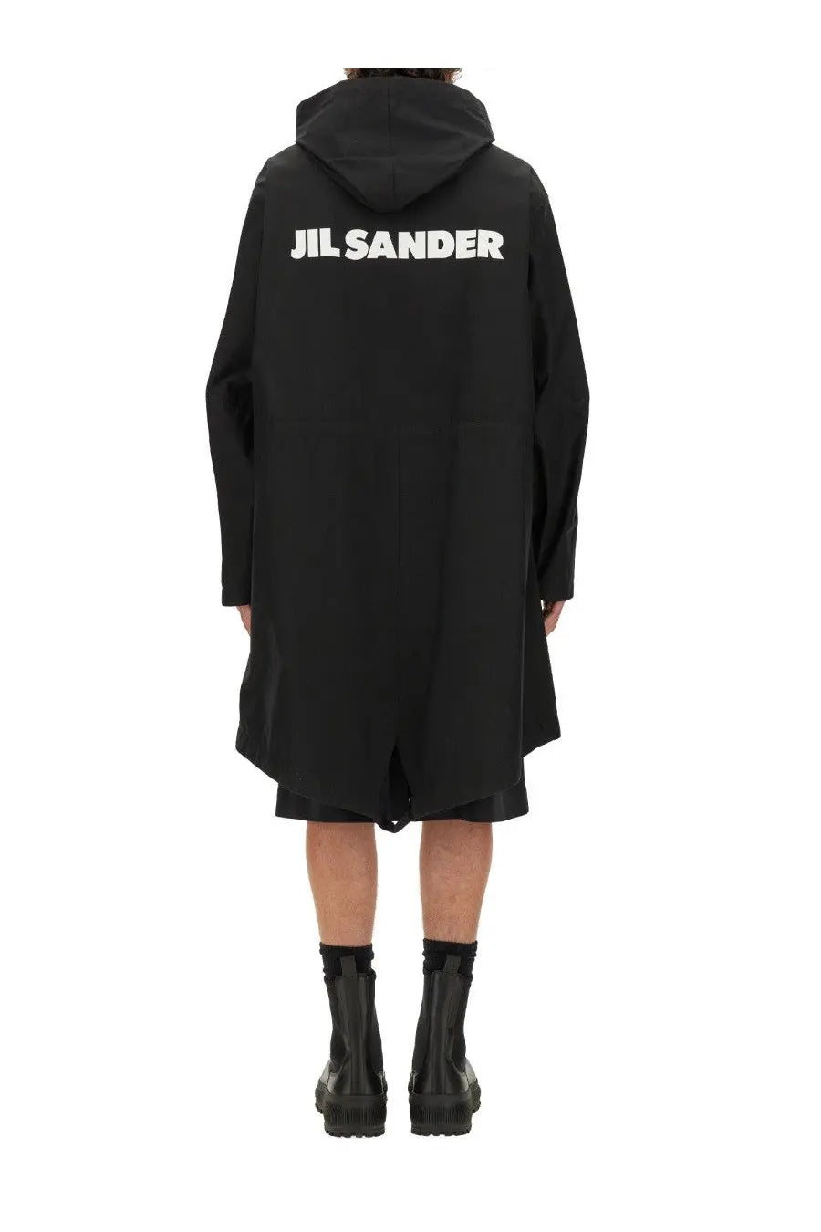 Back side of a black jil sander men’s parka hooded coat with bold white lettering across the back