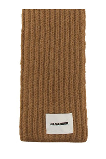 A tan ribbed knit jil sander men’s scarf with a white label at the bottom in beige color