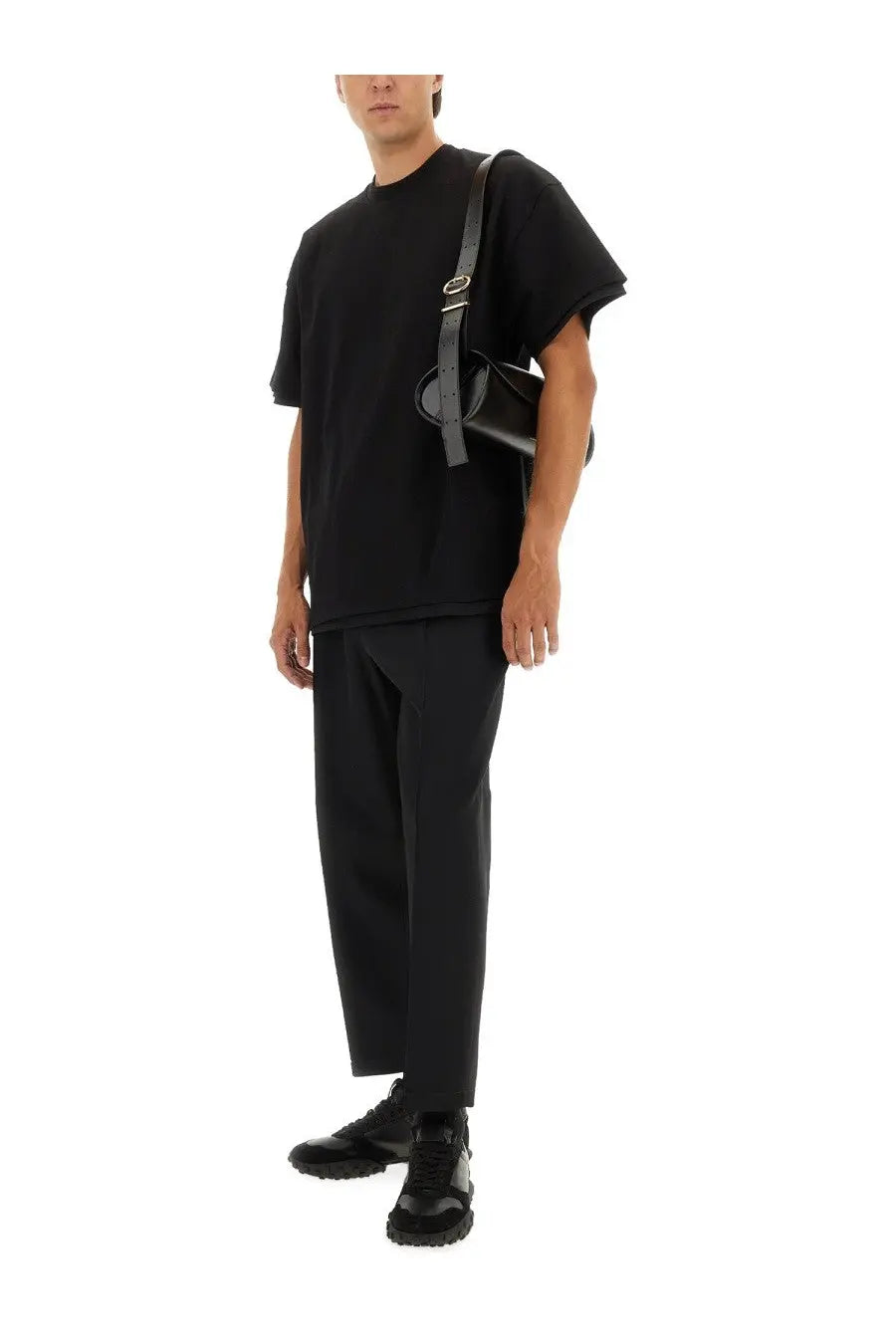 Black leather crossbody bag with sleek minimalist design and silver hardware paired with jil sander men’s tapered pants black