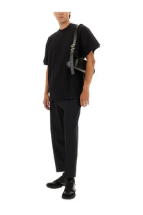 Black leather crossbody bag with sleek minimalist design and silver hardware paired with jil sander men’s tapered pants black