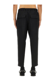 Jil Sander men’s tapered pants in black with elastic waistband and two large patch pockets in cotton blend fabric