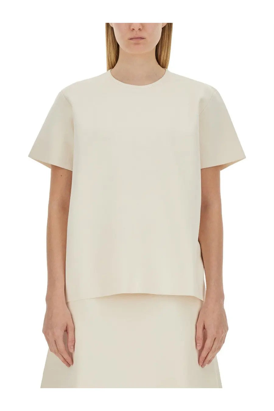 Cream-colored jil sander women’s boxy fit shirt with short sleeves and subtle asymmetrical hem in minimalist style