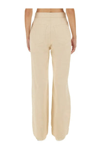 Beige jil sander women’s high-waisted wide-leg trousers with sleek tailored fit and two back pockets shown from back